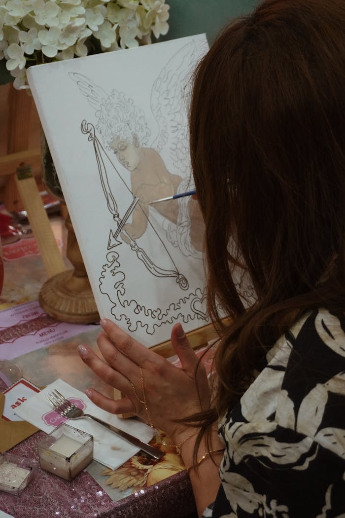 Artist painting a cherub on canvas in a cozy İzmir workshop.
